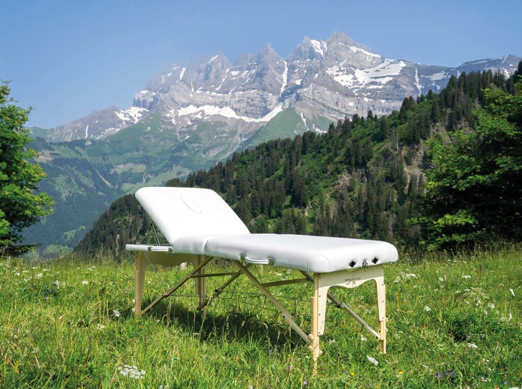 Table de massage pliable située dans la nature devant les Dents du Midi