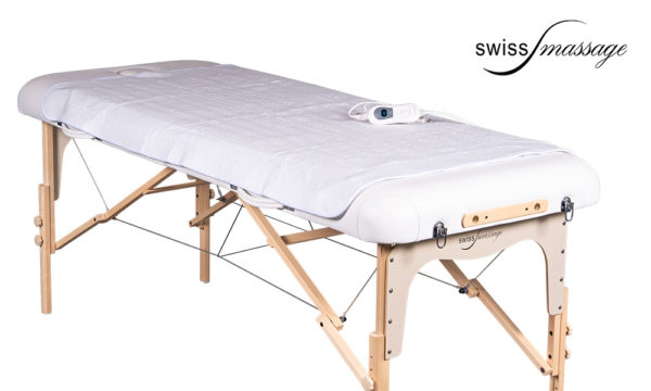 Couverture chauffante posée sur une table de massage pliable
