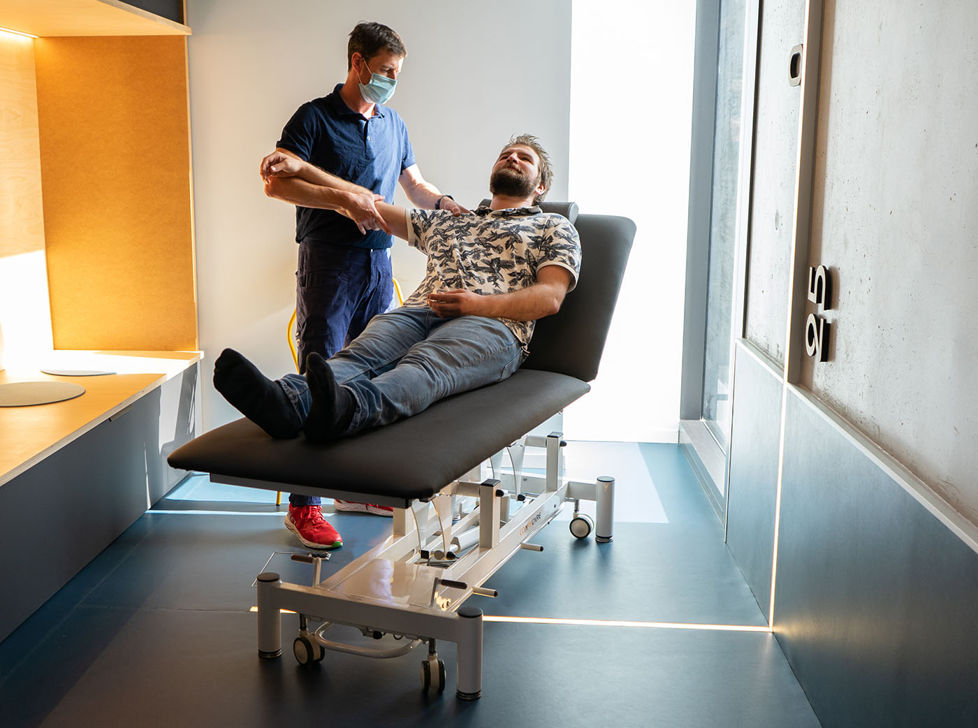 Mise en situation chez un physiothérapeute avec un patient sur une table d'examen